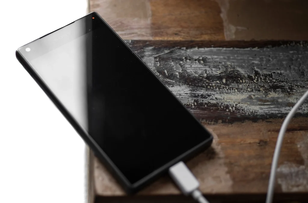 Close-up of a smartphone being charged, showing battery percentage indicator