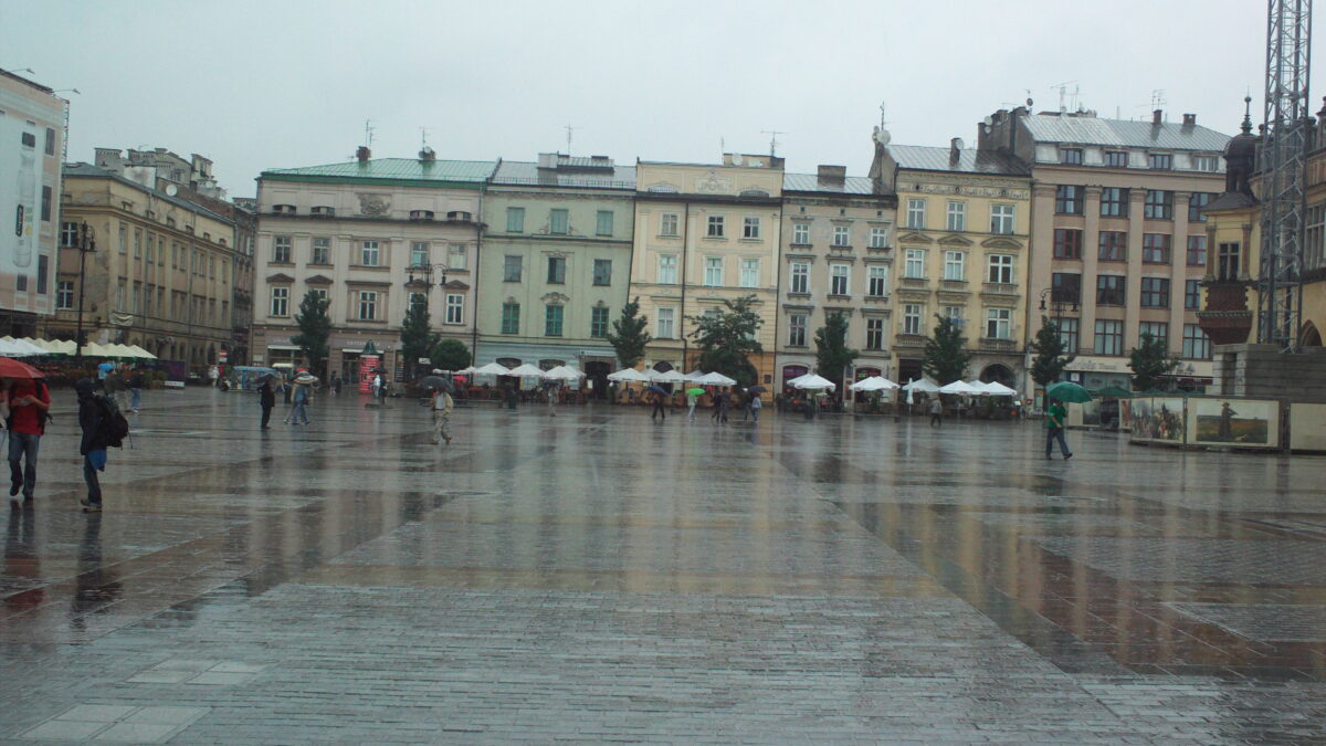 Historic market square in Kraków, Poland, with colourful buildings and tourists